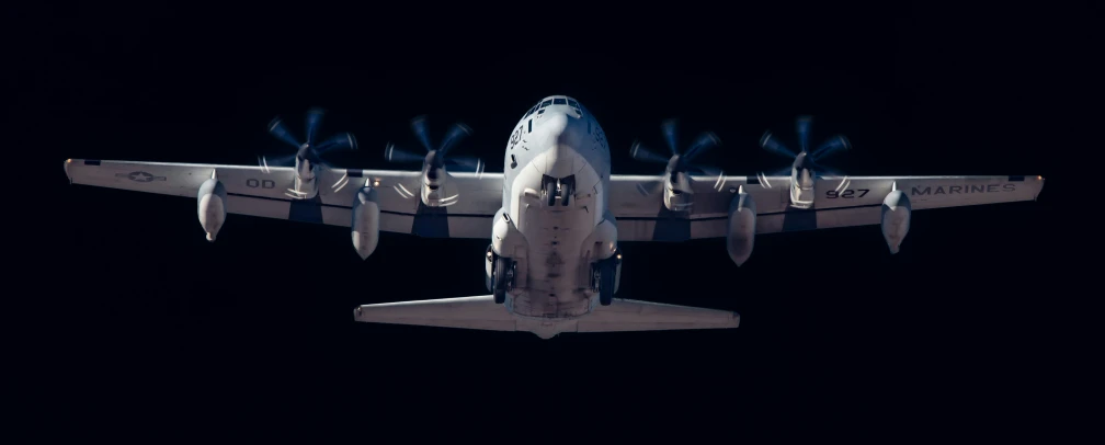 an airplane is flying at night with its wings extended