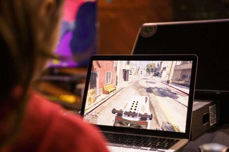 a  sits behind her laptop as the player plays on the computer