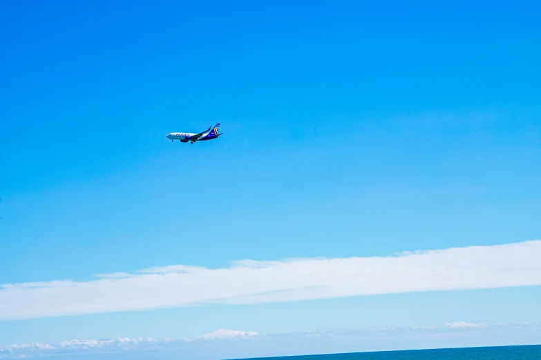 an airplane is flying through the sky above the water