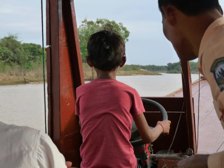 a boy and woman looking out on a river