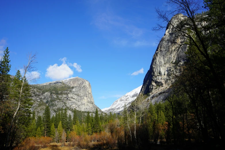 a valley surrounded by mountains under a bright blue sky