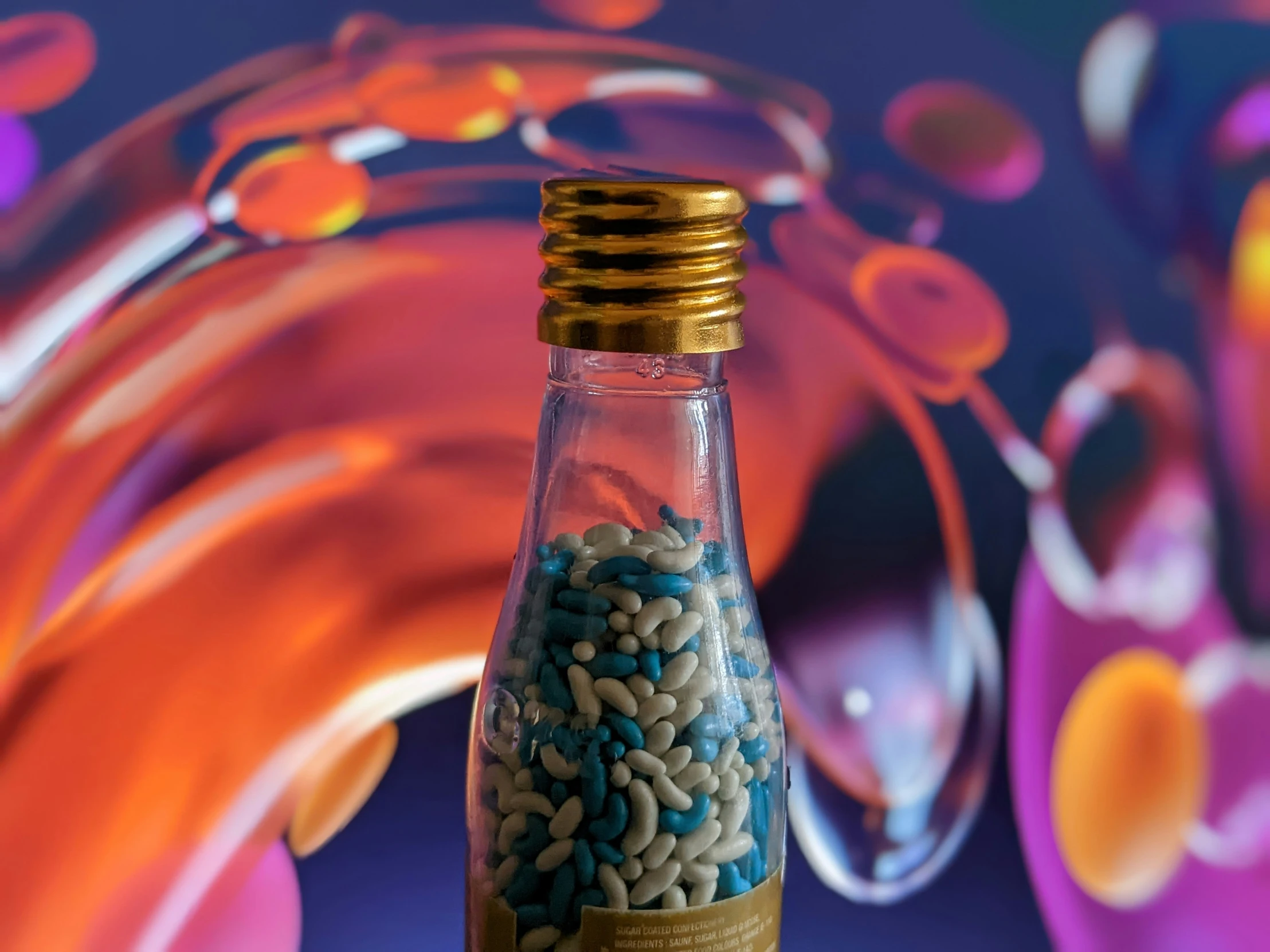 a bottle with blue and gold sprinkles in it