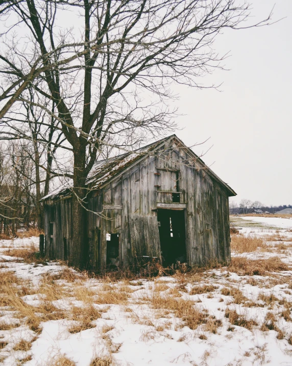 an old weathered barn in a snowy field