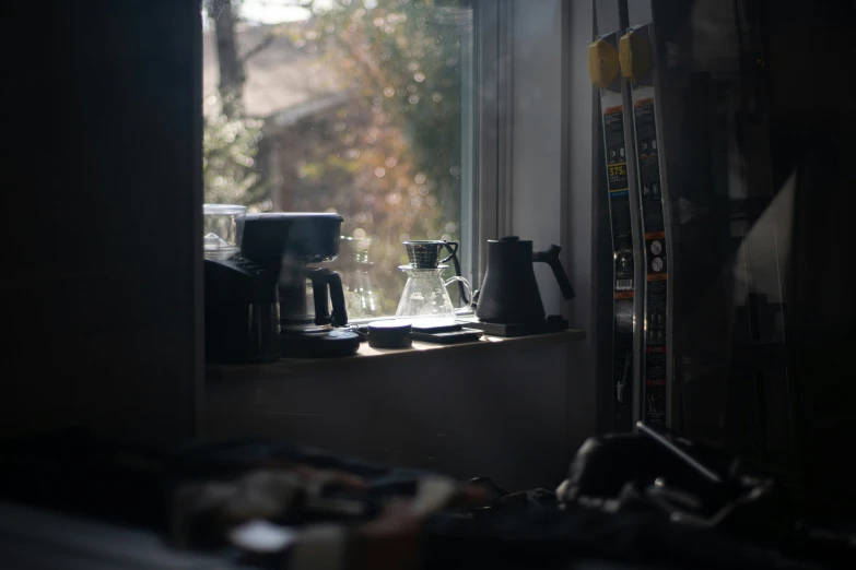 a coffee machine and cups on a window sill