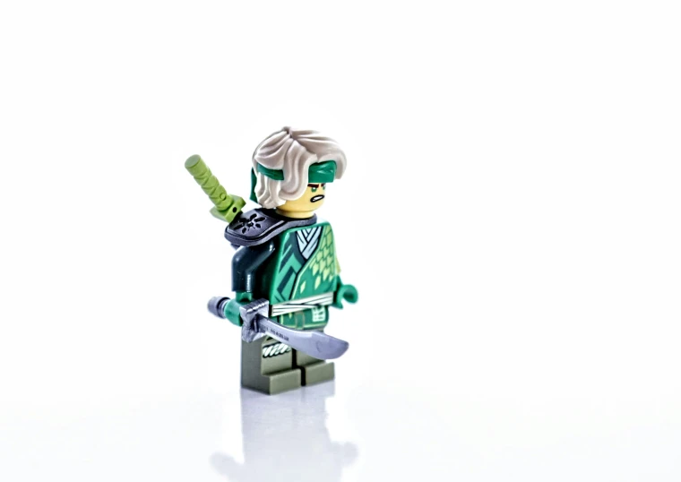 a lego batman standing on his side with a knife in hand