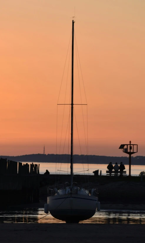 a small sailboat in the water with a light on