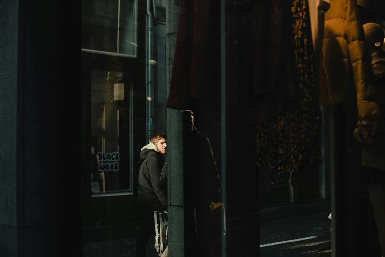 a young man is standing in front of a store