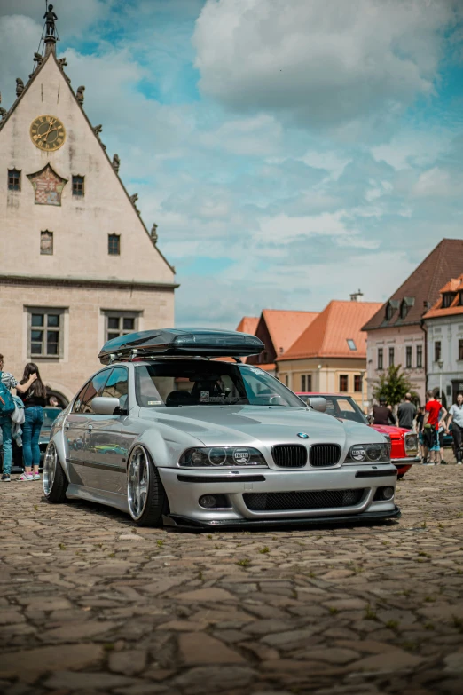 a silver bmw is parked near the side of the road