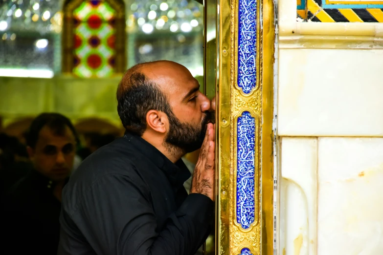 a man stands at a doorway to pray