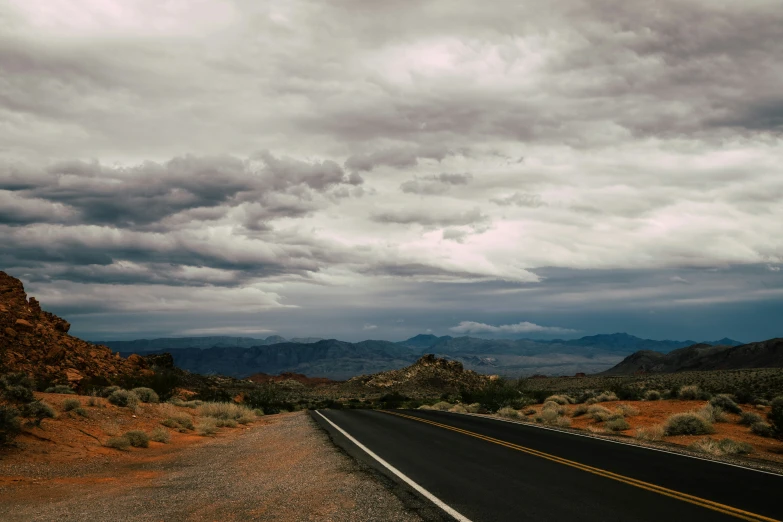 a road through a rocky desert with a big rock formation on either side