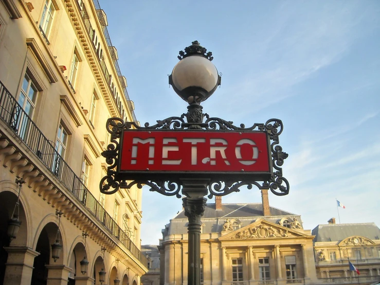 an ornate street sign and street lamp in the city