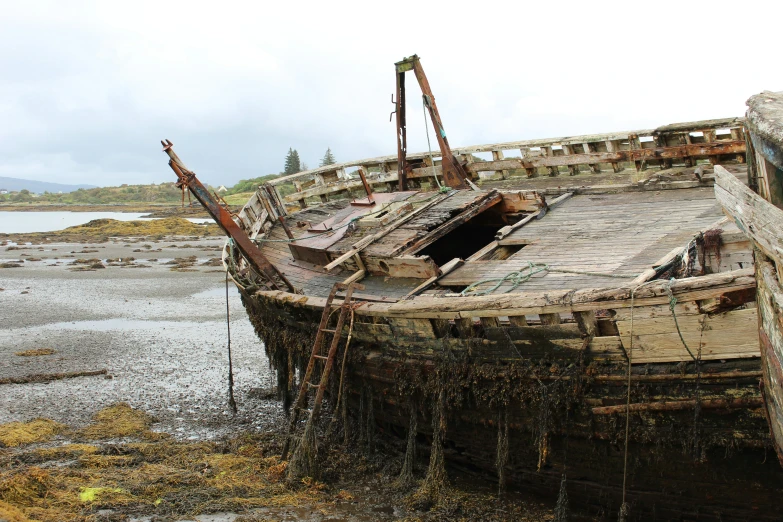 a derelict boat out on the shore in low tide