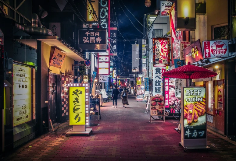 a street at night with a variety of stores on it