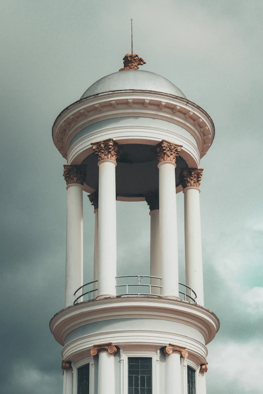 a white building with two pillars and a clock at the top