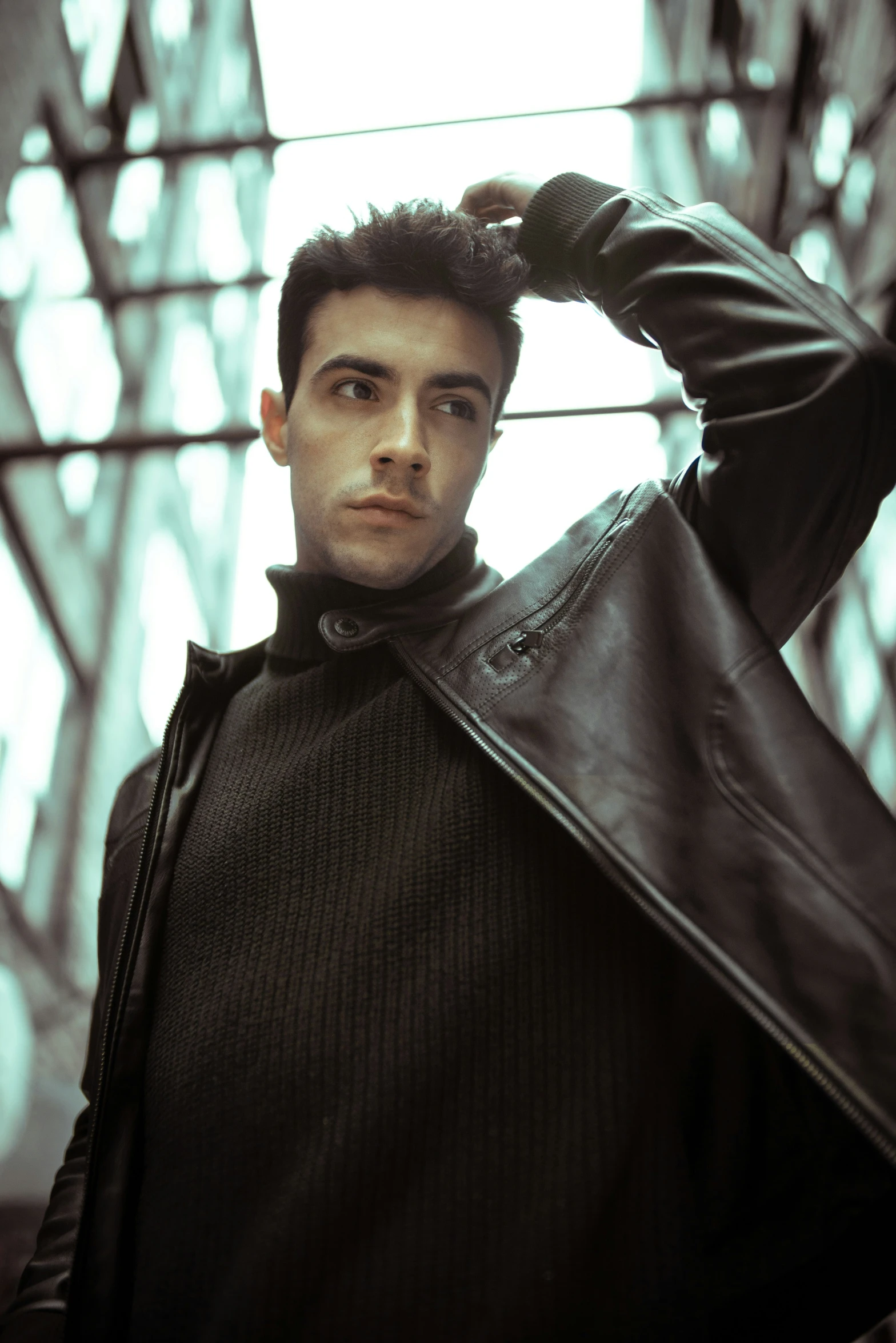 a man in a black leather jacket posing for the camera