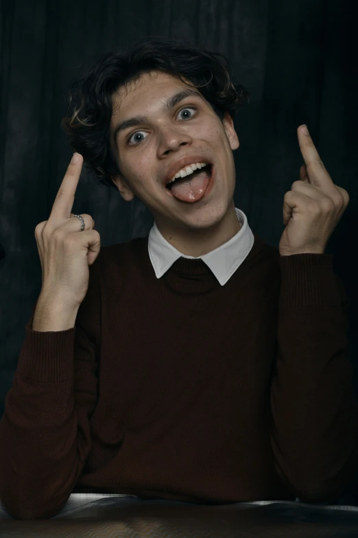 the boy smiles while he shows his two finger signs