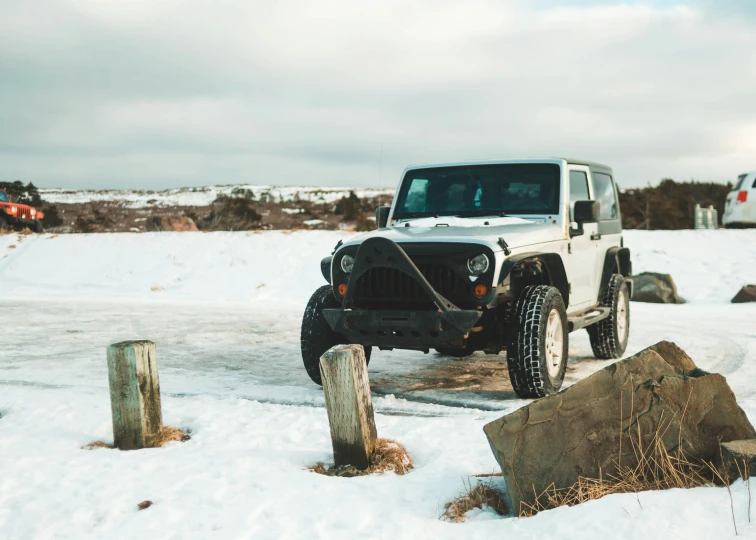 a jeep is driving through the snow in a lot