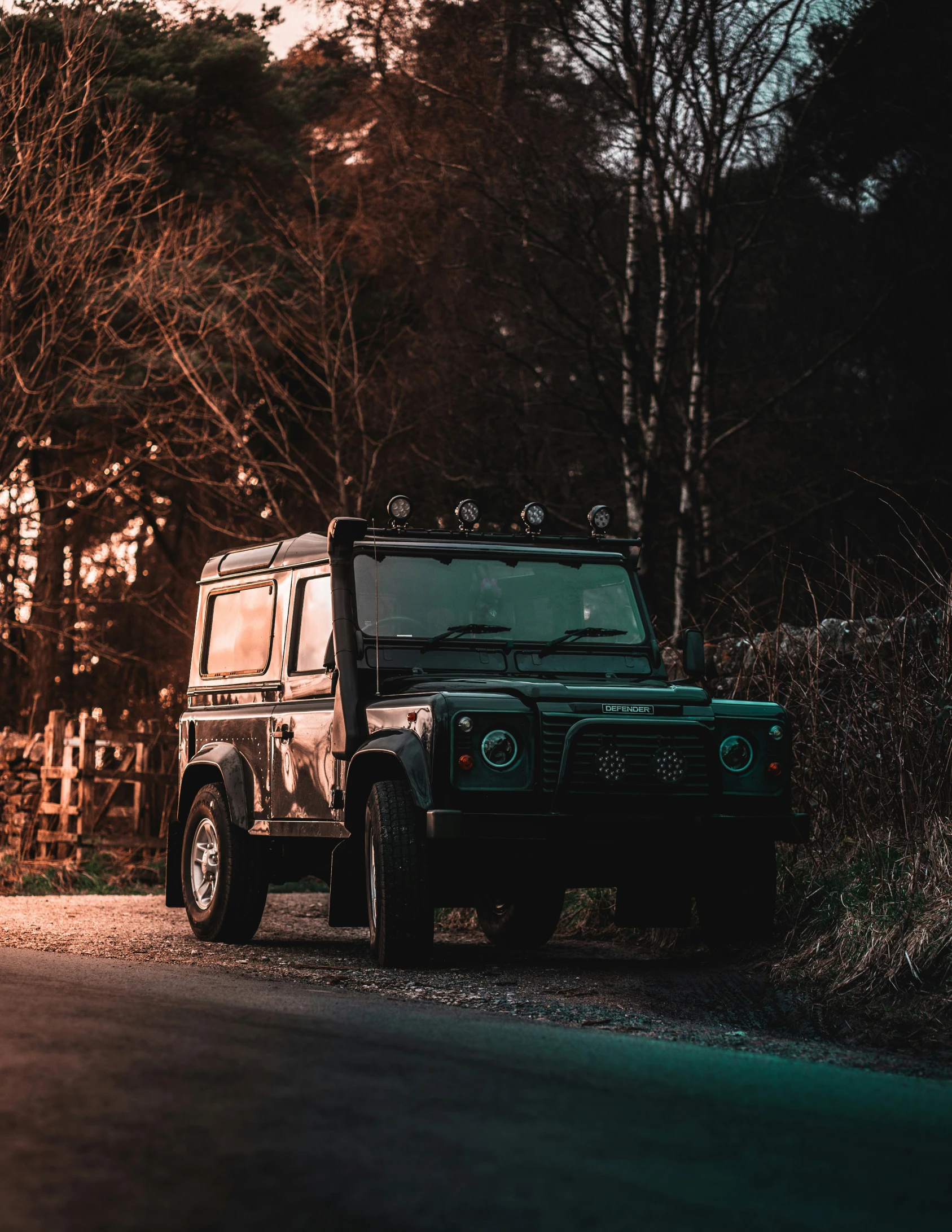 a jeep sitting on the side of a road next to a forest