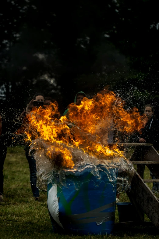 a fire in a barrel being used as a trash can