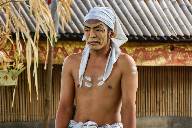 an indian man is dressed up in white with feathers on his head