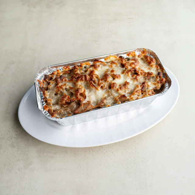 a rectangular lasagna with sauce on a white plate