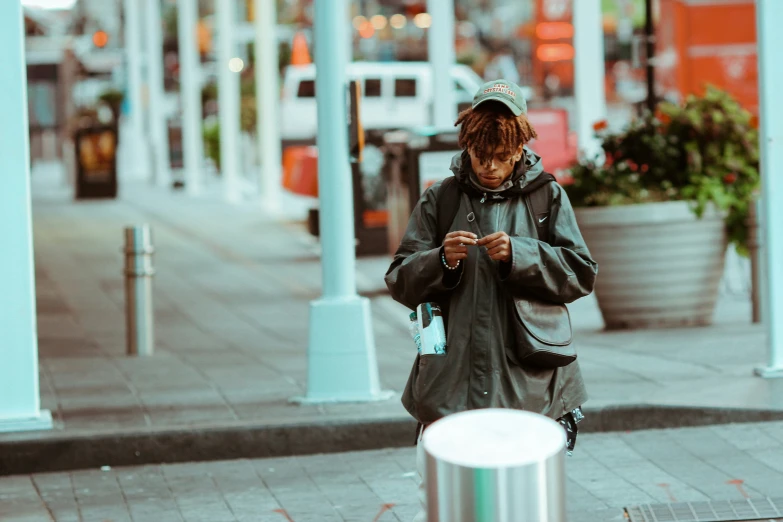 a woman walking down the street while looking at her cellphone