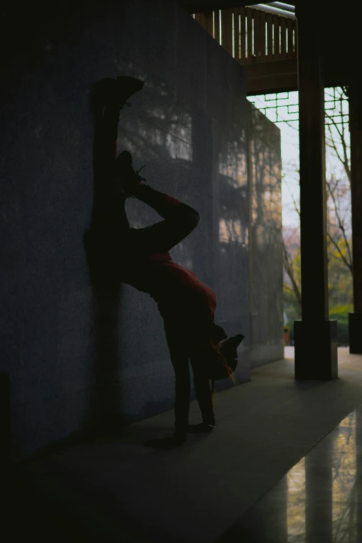 a woman holding onto a wall with one hand