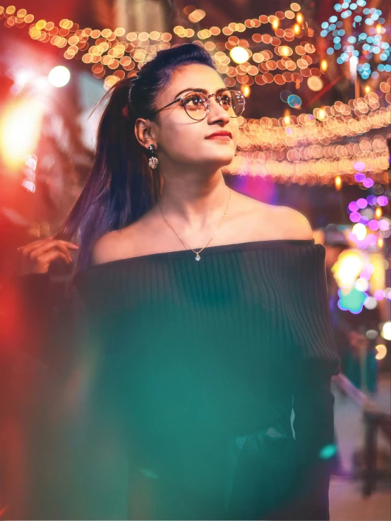 a woman is standing near a store with lights