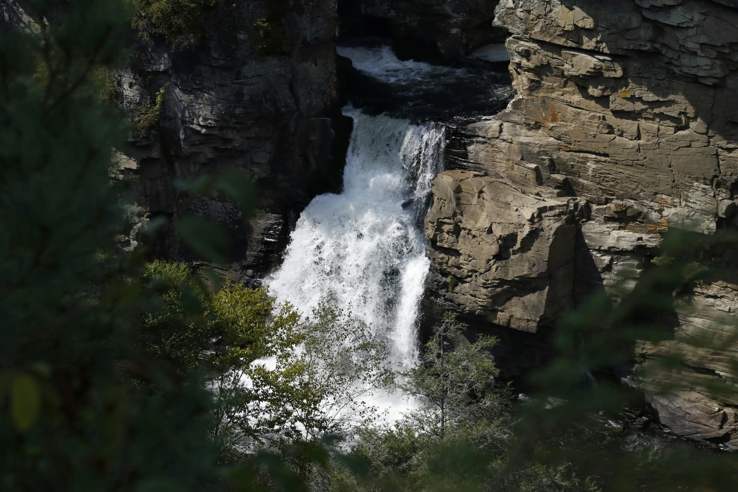 a river running over rocks into a waterfall