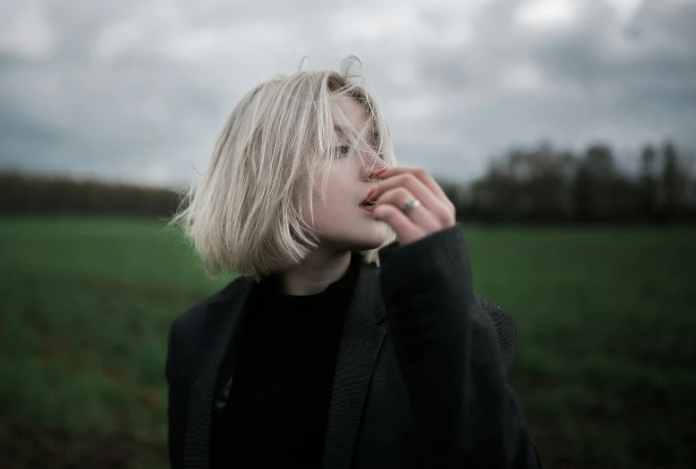 a  poses with her hand near her mouth