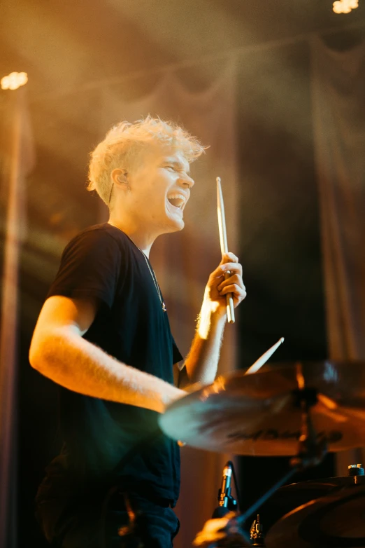 a man standing on a stage holding a drum