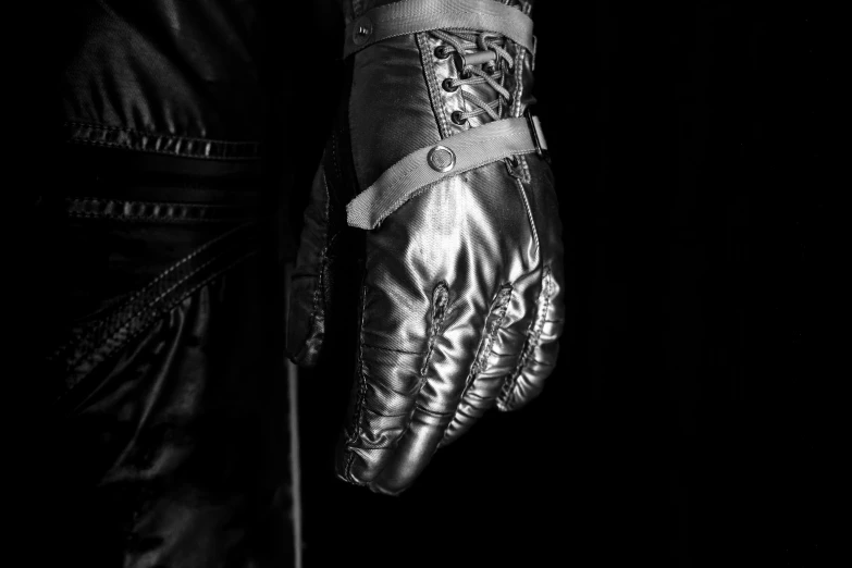 a black and white po of a man wearing a shiny glove