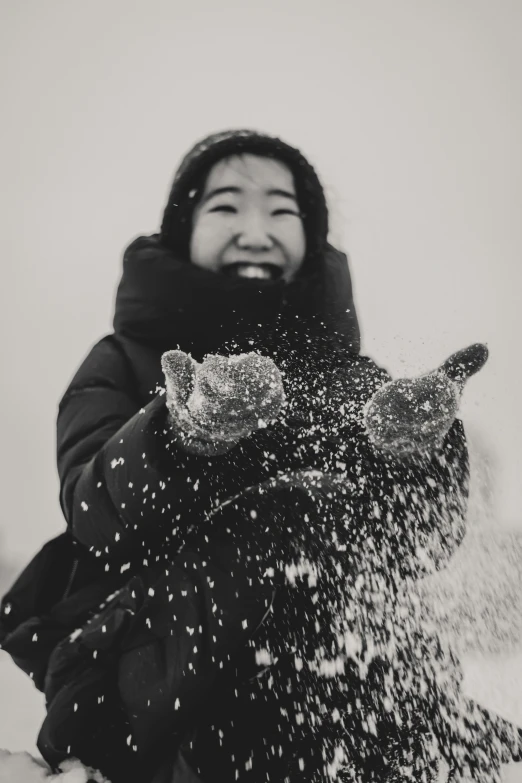 a woman is throwing snow in the air