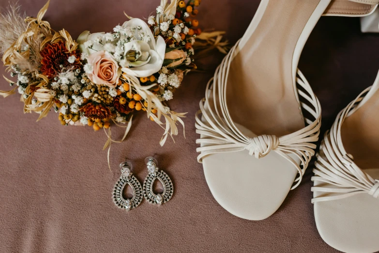 a bridal dress and wedding bouquet sitting on the ground