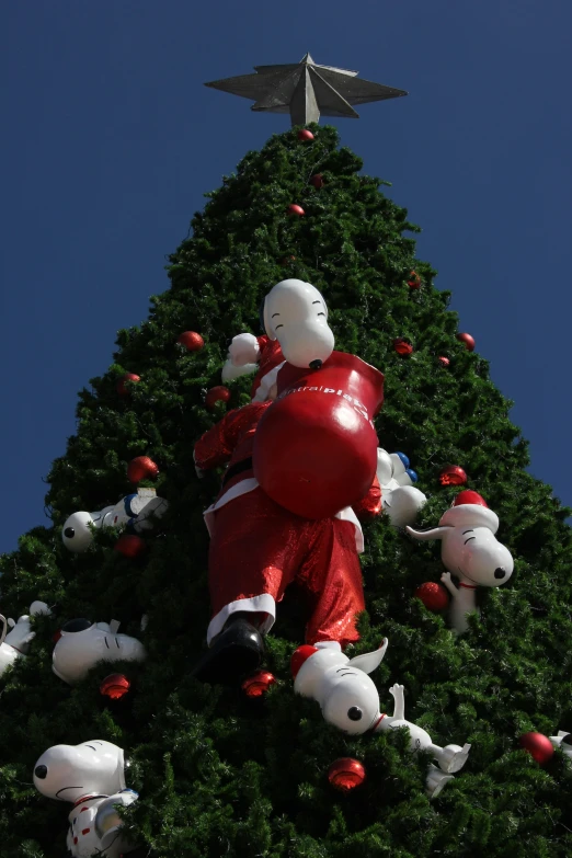 a christmas tree with stuffed toys around the bottom