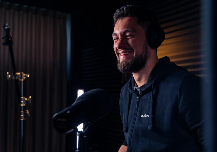 a man sitting in front of a microphone wearing headphones