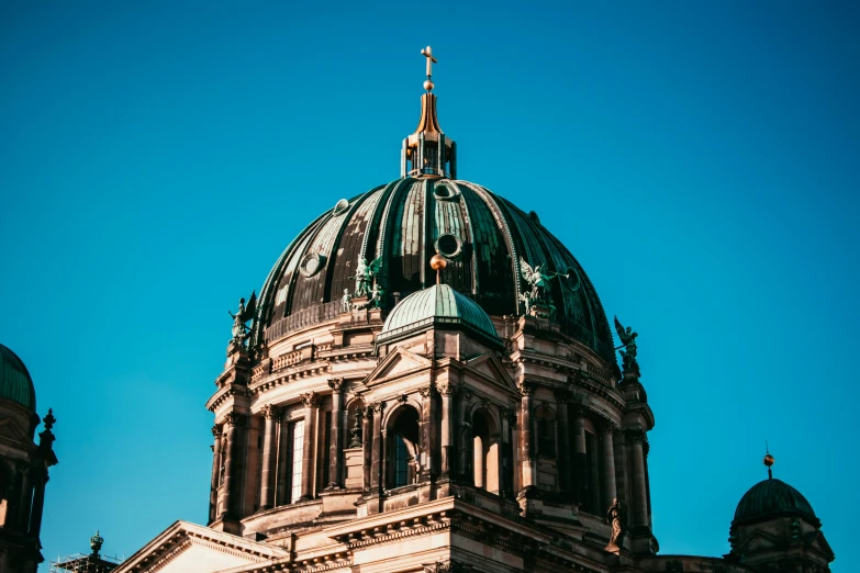 a tall building with domes on top against a blue sky