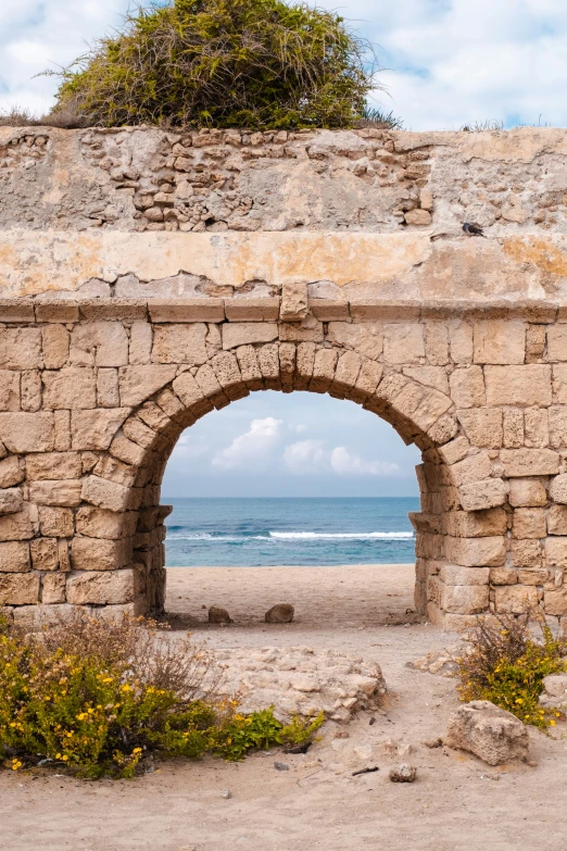 an archway to a beach that extends into the ocean