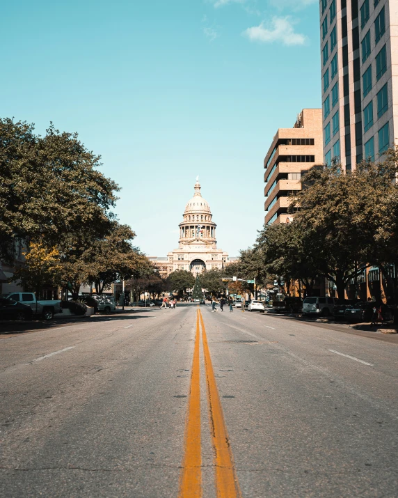 an empty road in front of tall buildings