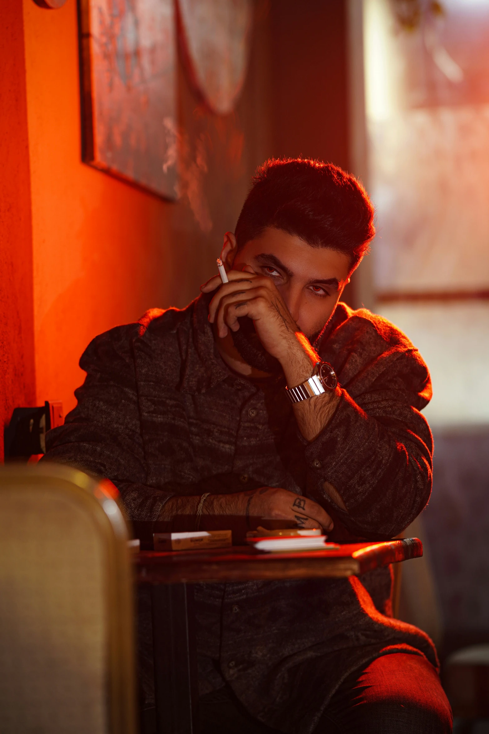 a man sitting in a chair talking on a cell phone