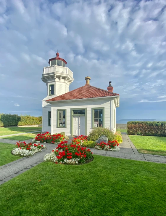 small lighthouse with plants and flowers on a green lawn