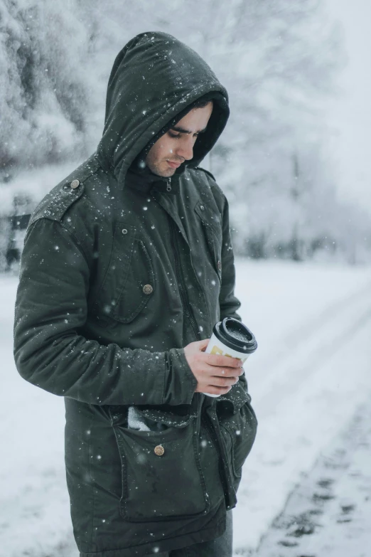 a young man is enjoying a cold drink in the snow