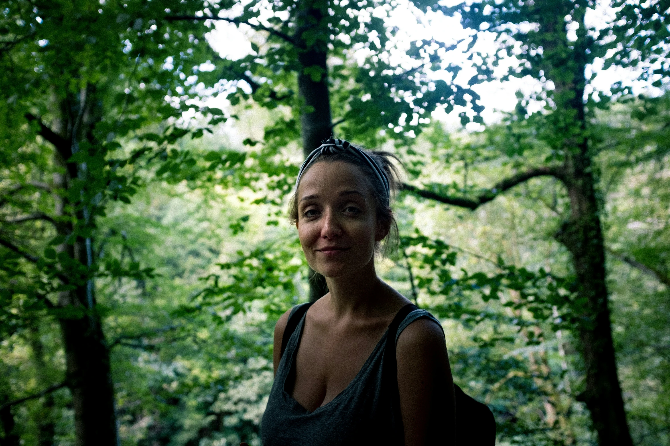 a woman with a headband posing for a picture in the forest