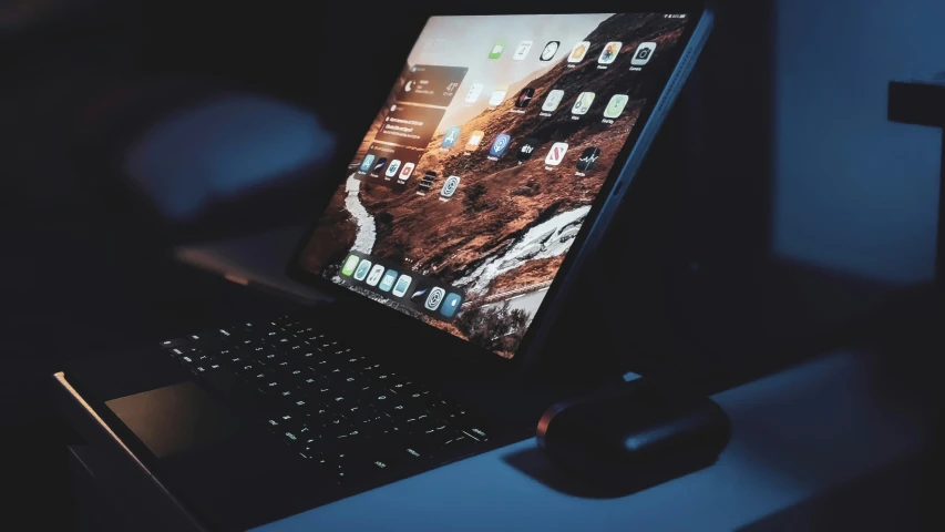 a lap top sits next to an external mouse