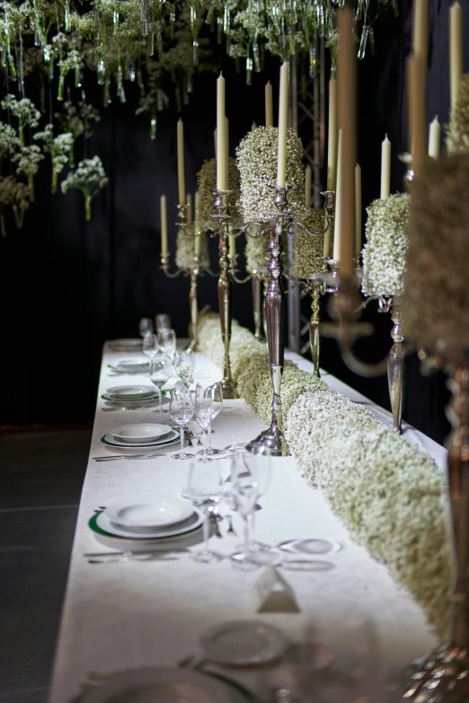 a dinner table with plates and candle holders