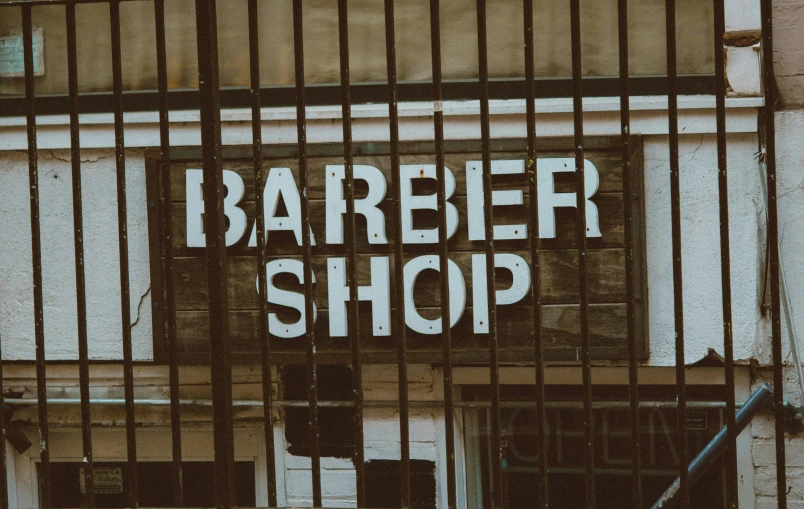 a shop sign with barred metal wire over it
