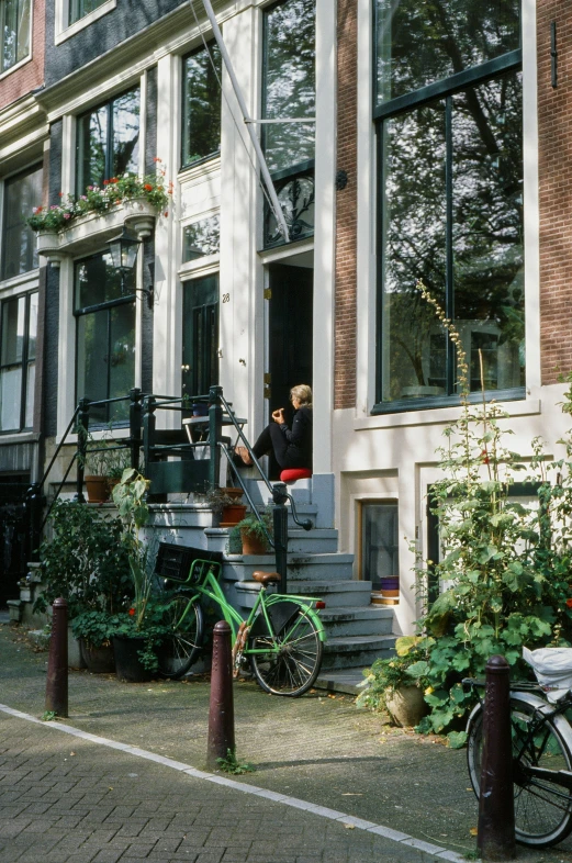 two people sitting on the steps of a house