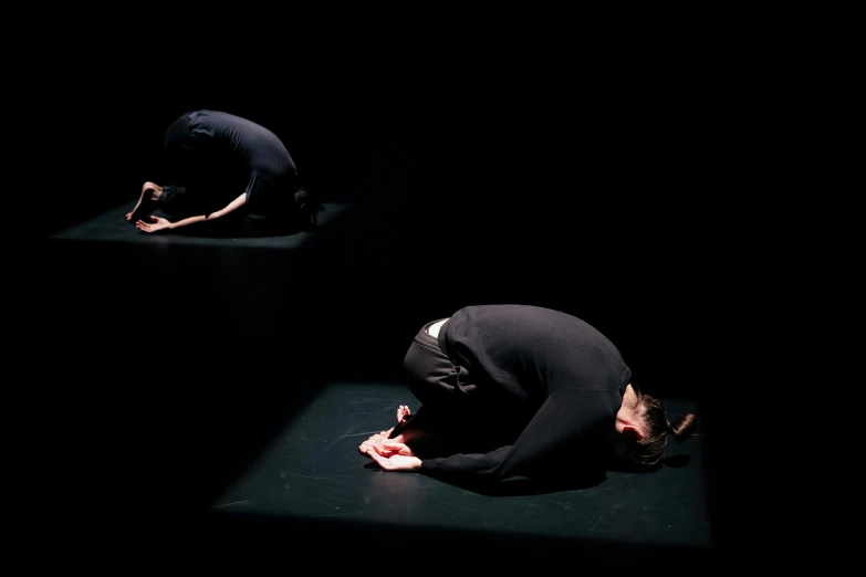 a man kneeling on top of a black ground