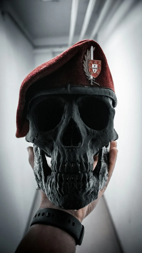 someone is wearing a red beret that has a skull in it