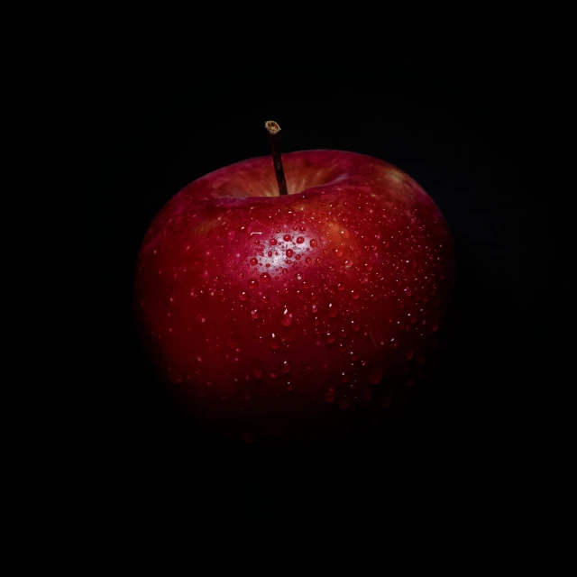 the apple is glowing red on a black background